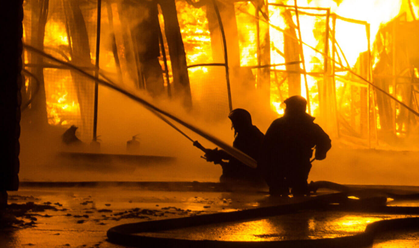 Two fire fighters fighting a blaze